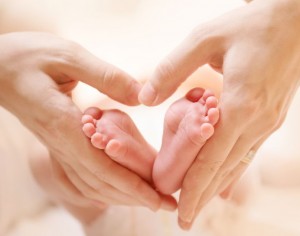 Baby feet in mother hands. Tiny Newborn Baby's feet on female He